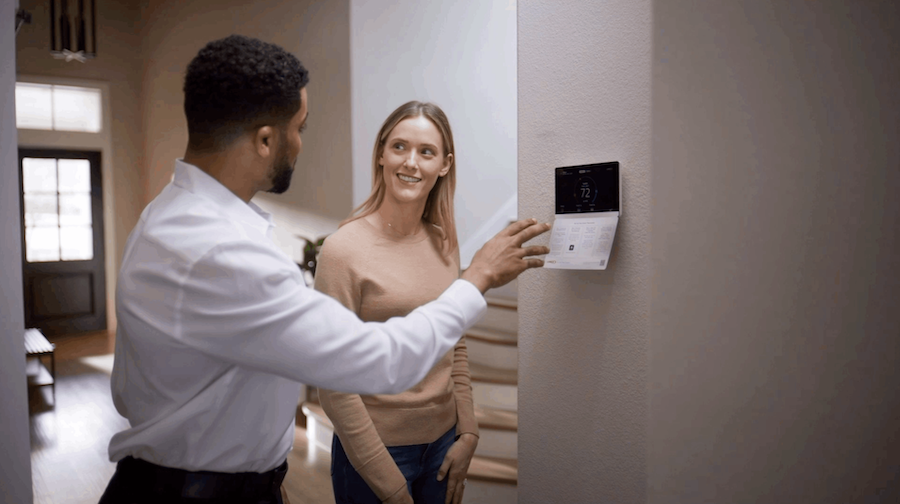 Technician showing a homeowner how to use a smart thermostat