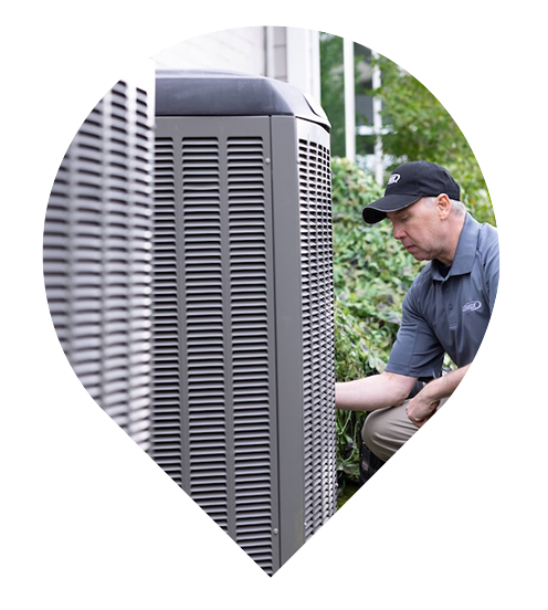Purified Air technician inspecting an outdoor AC condenser unit